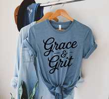 Load image into Gallery viewer, Denim colored shirt stating grace and grit pictured on a hanger