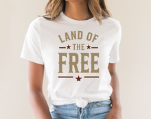 Load image into Gallery viewer, White t-shirt with 'Land of the Free' text worn by a person on a plain background