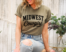 Load image into Gallery viewer, Woman wearing a green t-shirt with 'Midwest Cowgirl' text, sitting outdoors.