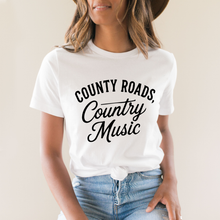 Load image into Gallery viewer, Person wearing a white t-shirt with 'County Roads, Country Music' text.