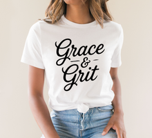 Load image into Gallery viewer, Person wearing a white t-shirt with 'Grace &amp; Grit' text on a plain background